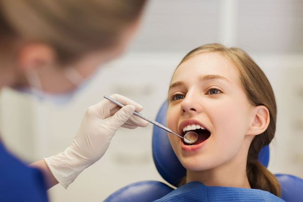 odontólogo revisando a paciente menor de edad